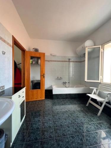 a bathroom with a tub and a sink at casa solemar in La Maddalena