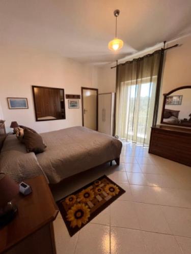 a bedroom with a bed and a rug on the floor at casa solemar in La Maddalena