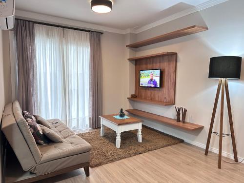 a living room with a couch and a table at Apartamento acolhedor ideal para um casal in Canela