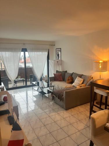 un salon avec un canapé et une table dans l'établissement Agréable appartement climatisé devant la mer avec parking, à Antibes