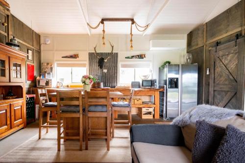 a kitchen and dining room with a table and refrigerator at The Woolshed in Lake Tarawera