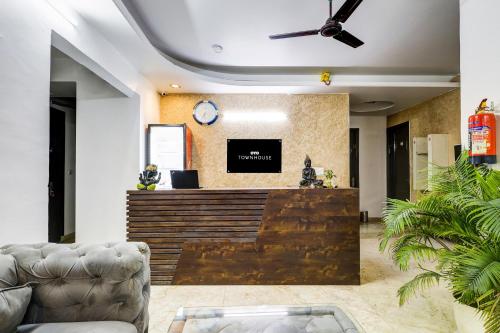 een lobby met een receptie met een klok aan de muur bij Super Townhouse Mayfield Garden Nearby Golf course road in Gurgaon