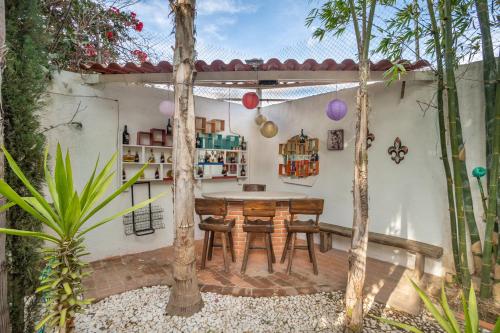 a patio with a table and chairs in a garden at Villa a 10 mins de Tx 5 habs 6 baños jacuzzi brincolín in Tequisquiapan