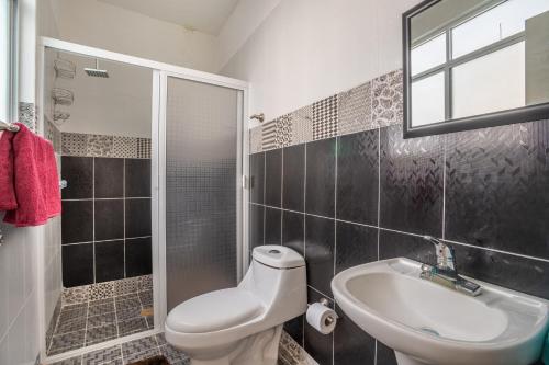 a bathroom with a toilet and a sink and a shower at Villa a 10 mins de Tx 5 habs 6 baños jacuzzi brincolín in Tequisquiapan