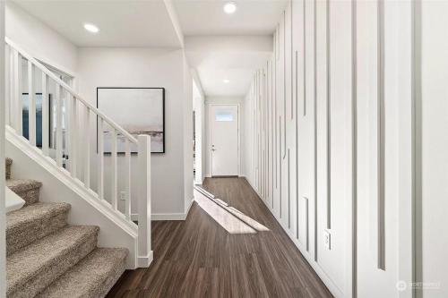 a hallway with white walls and stairs in a house at Serene Port Orchard Retreat - 3BR 3BA with Trails and Amazing Views in Port Orchard