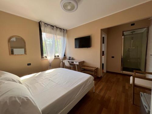 a bedroom with a large white bed and a bathroom at La Rosa del Golfo dei Poeti in La Spezia