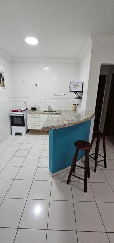 a kitchen with a counter and a chair in it at Edifício Belluno in Ribeirão Preto