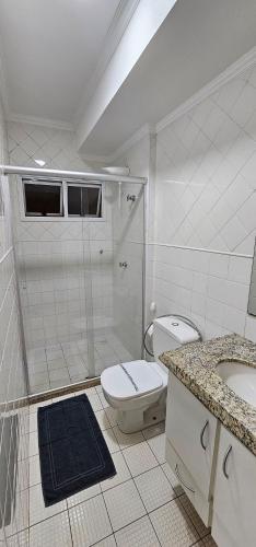 a bathroom with a toilet and a shower and a sink at Edifício Belluno in Ribeirão Preto