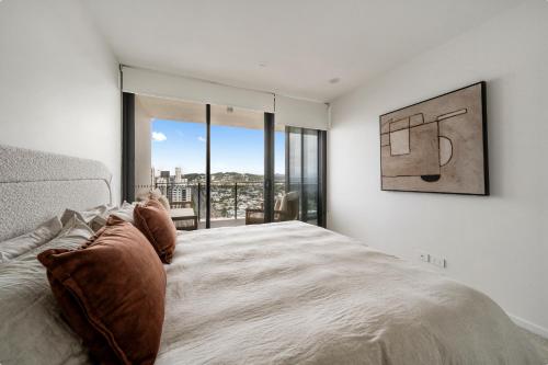 a bedroom with a bed and a large window at Seren - Luxury Ocean Views With Pool And Gym in Gold Coast