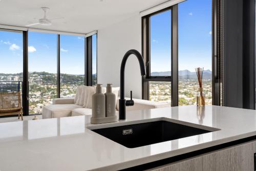 a kitchen with a sink and large windows at Seren - Luxury Ocean Views With Pool And Gym in Gold Coast