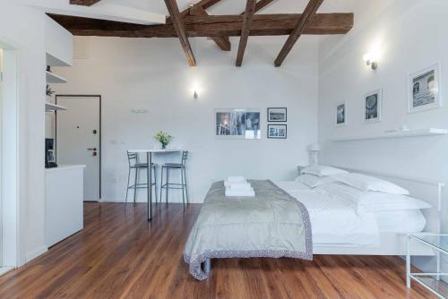 a white bedroom with a bed and a table at Apartment The Charm in Split