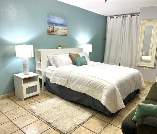 a bedroom with a bed and a lamp and a couch at 3BDR Wi-Fi Parking Pool AC 2 min from the Beach Deposit Required in Cabo Rojo
