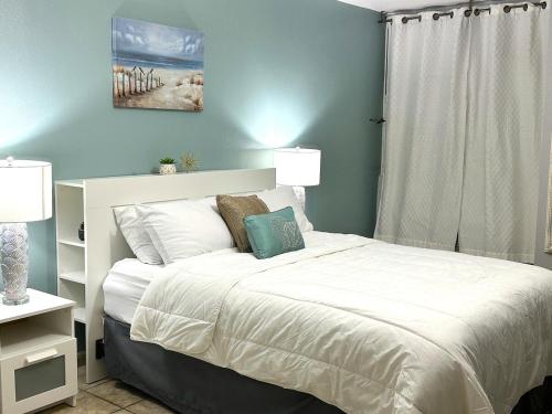 a bedroom with a bed with white sheets and a window at 3BDR Wi-Fi Parking Pool AC 2 min from the Beach Deposit Required in Cabo Rojo