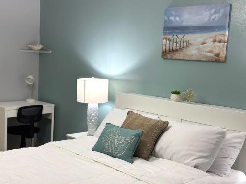a bedroom with a white bed with a blue wall at 3BDR Wi-Fi Parking Pool AC 2 min from the Beach Deposit Required in Cabo Rojo