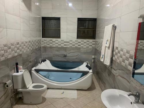a bathroom with a tub and a toilet and a sink at Lakepoint Villa in Entebbe