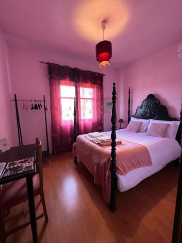 a bedroom with a large bed and a table at Alojamento local Os Maias in Mirandela