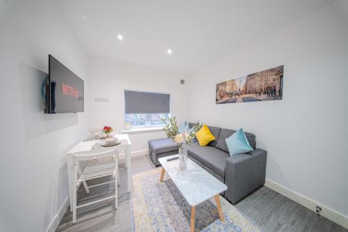 a living room with a couch and a table at Ilford Luxury Apartments in Ilford