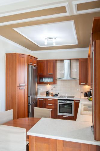 a kitchen with wooden cabinets and a ceiling at Nireas Blue Balcony by Raise in Áno Váthia