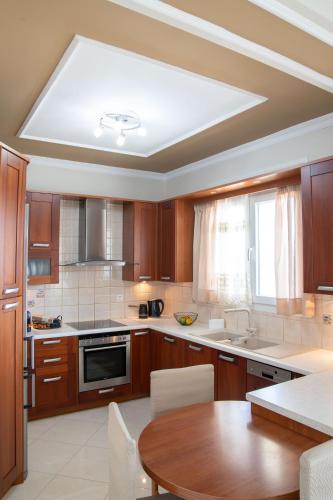 a large kitchen with a table and a ceiling at Nireas Blue Balcony by Raise in Áno Váthia