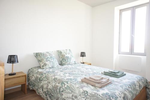 une chambre avec un lit avec des serviettes dessus dans l'établissement Appartement la Dolce Via, à La Voulte-sur-Rhône
