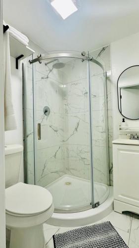 a white bathroom with a shower and a toilet at Modern 1BR Suite Boutique 5 Miles to Beach in Clearwater