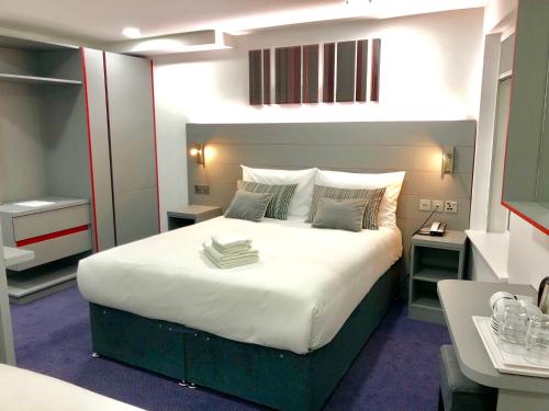 a bedroom with a large white bed in a room at Ilford Hotel Goodmayes in Ilford
