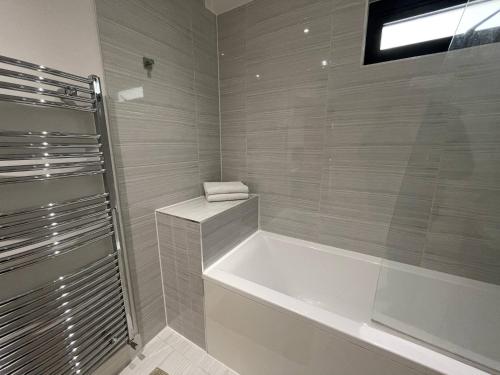 a bathroom with a bath tub and a window at Ilford Tower Apartments in Ilford