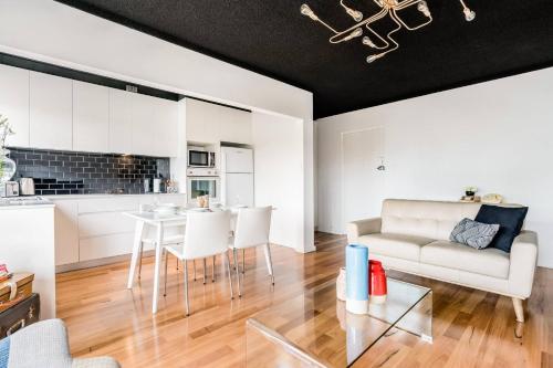 a living room with a couch and a table at Renovated Retro Apartment Near Harbour Front Walks in Sydney