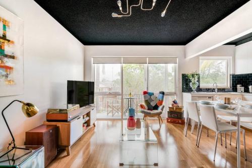 a living room with a table and a dining room at Renovated Retro Apartment Near Harbour Front Walks in Sydney