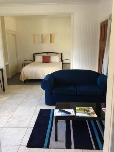 a living room with a blue couch and a bed at Horsepower Cabins in Warwick