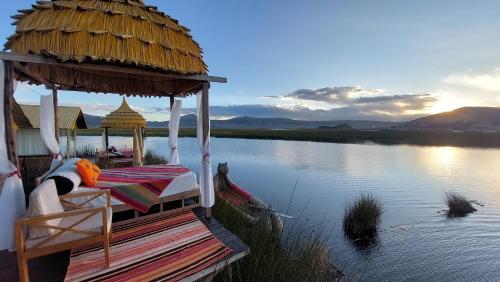 a boat with a bed and a straw roof on a river at Uros Lodge Perú in Puno