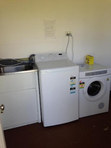 a washing machine and a sink in a kitchen at Horsepower Cabins in Warwick