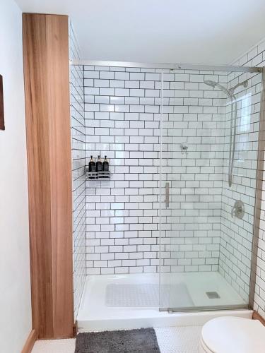 a white tiled shower with a glass door in a bathroom at Enchanting Private Forest Retreat near Mt Rainier in Mineral
