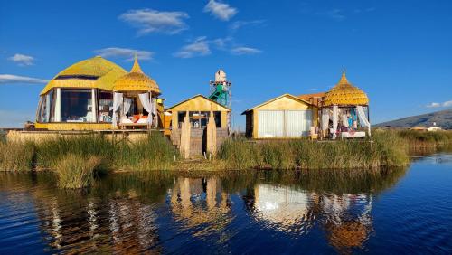 a group of houses sitting next to a body of water at Uros Lodge Perú in Puno