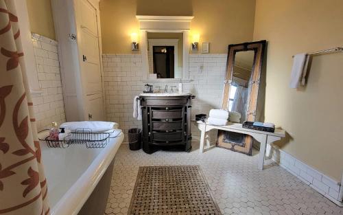 a bathroom with a tub and a sink and a mirror at The New Victorian Mansion Bed & Breakfast in Saint Paul