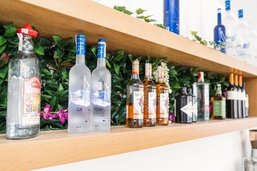 a row of bottles of alcohol on a shelf at Avis Hotel in Novalja