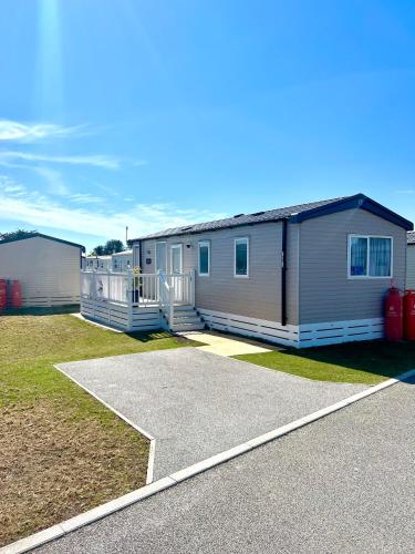 a row of mobile homes parked in a yard at The Driftwood Den in Tywardreath