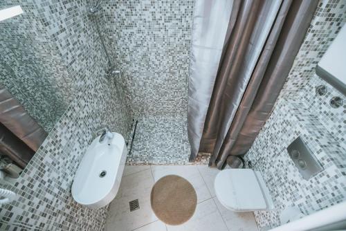 a bathroom with a tub and a toilet and a sink at Avis Hotel in Novalja