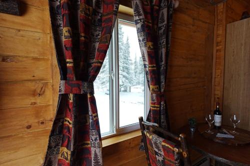 a window in a wooden cabin with a table and a table at Moose-AKa's Cabins in Healy