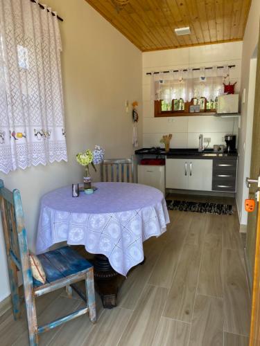 a kitchen with a table and a kitchen with a counter at Casa Aconchegante na Montanha in Campos do Jordão