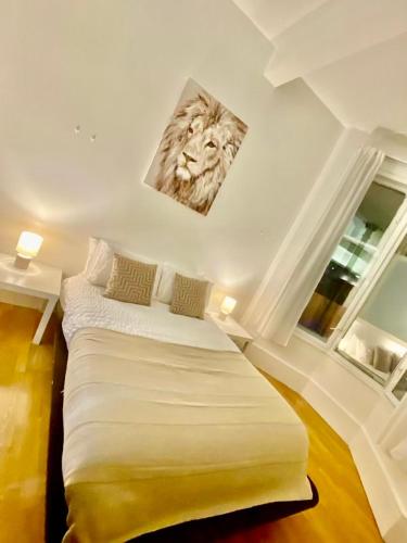 a bedroom with a large bed in a room with two windows at Cozy Studio Apartment in Leeds