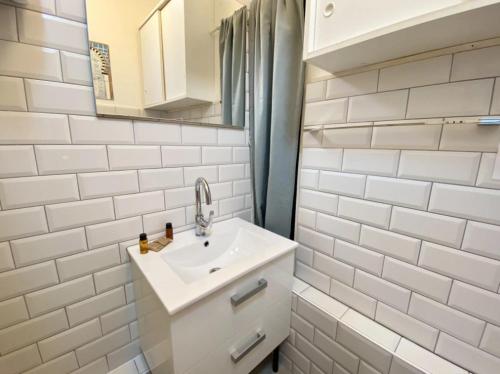 une salle de bain blanche avec un lavabo et un miroir dans l'établissement Nice City Center-Beach Escape, à Nice