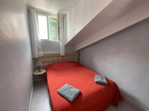 - une chambre avec un lit rouge et 2 oreillers dans l'établissement Nice City Center-Beach Escape, à Nice