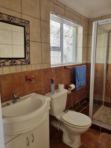 a bathroom with a toilet and a sink and a tub at Bargain for 8 persons in Fish Hoek