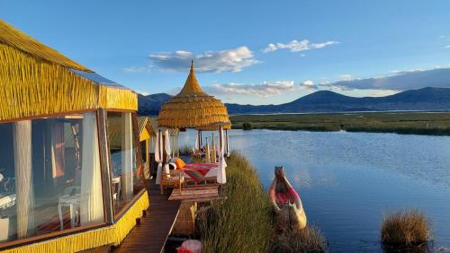 a house with a gazebo next to a lake at Uros Lodge Perú in Puno