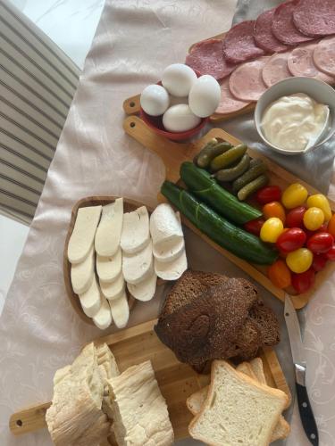 a table topped with different types of cheese and vegetables at Cornicello guest haus in Tbilisi City