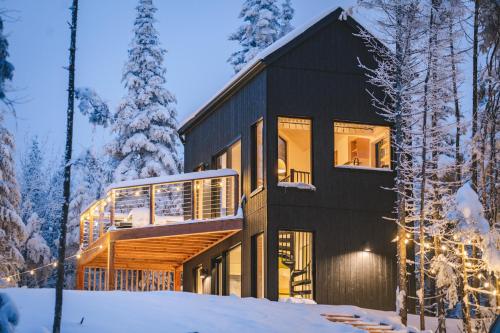 a house in the woods in the snow at Landskäp - Panoramic View With Spa Near Quebec City in Lac-Beauport