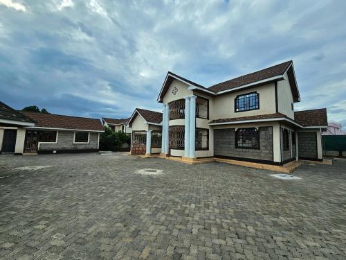 a large house with a driveway in front of it at pinlifehomes in Naro Moru