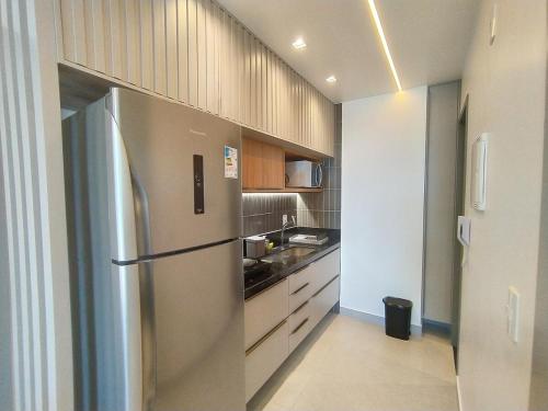 a kitchen with a stainless steel refrigerator and a sink at Studio Manaíra #SSR802 Prox Shop in João Pessoa