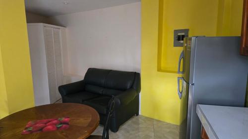 a kitchen with a table and a chair and a refrigerator at Wizzy Apartment White River in Ocho Rios
